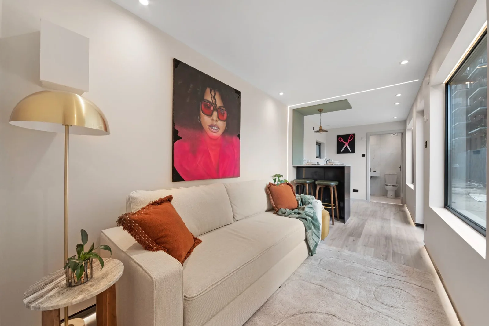 Residential Unit 27 living room with sofa, colourful artwork and large windows