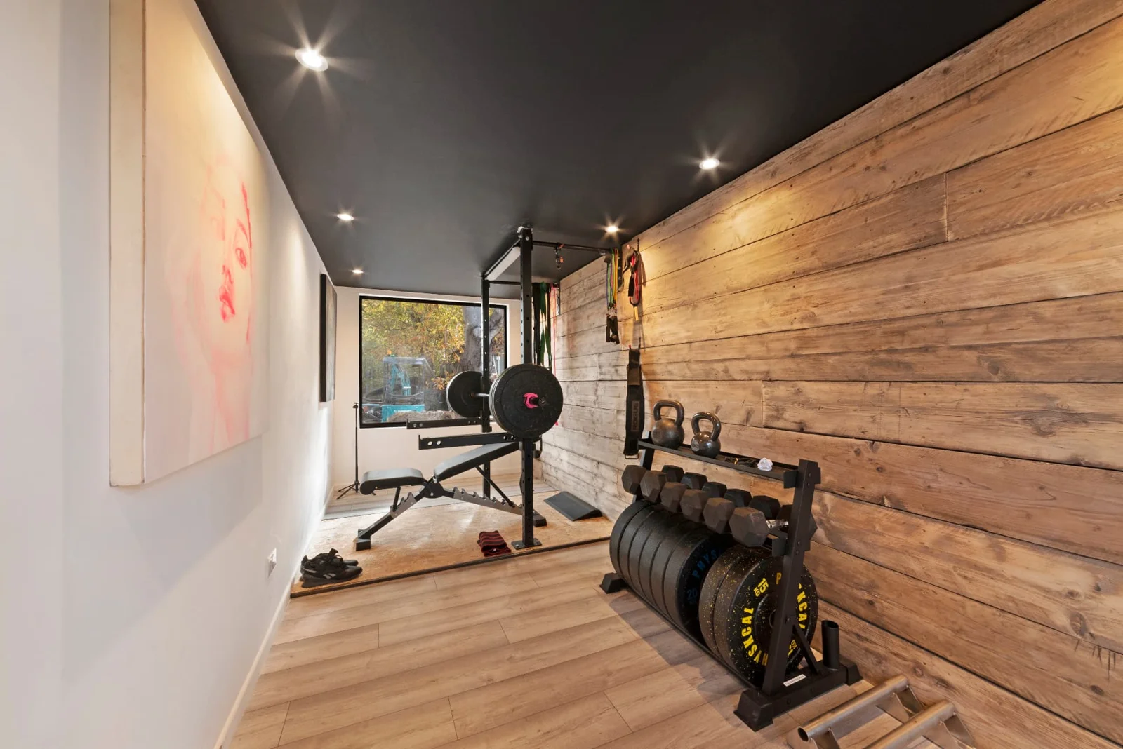 Gym container with dumbbells, weight rack and timber-lined wall