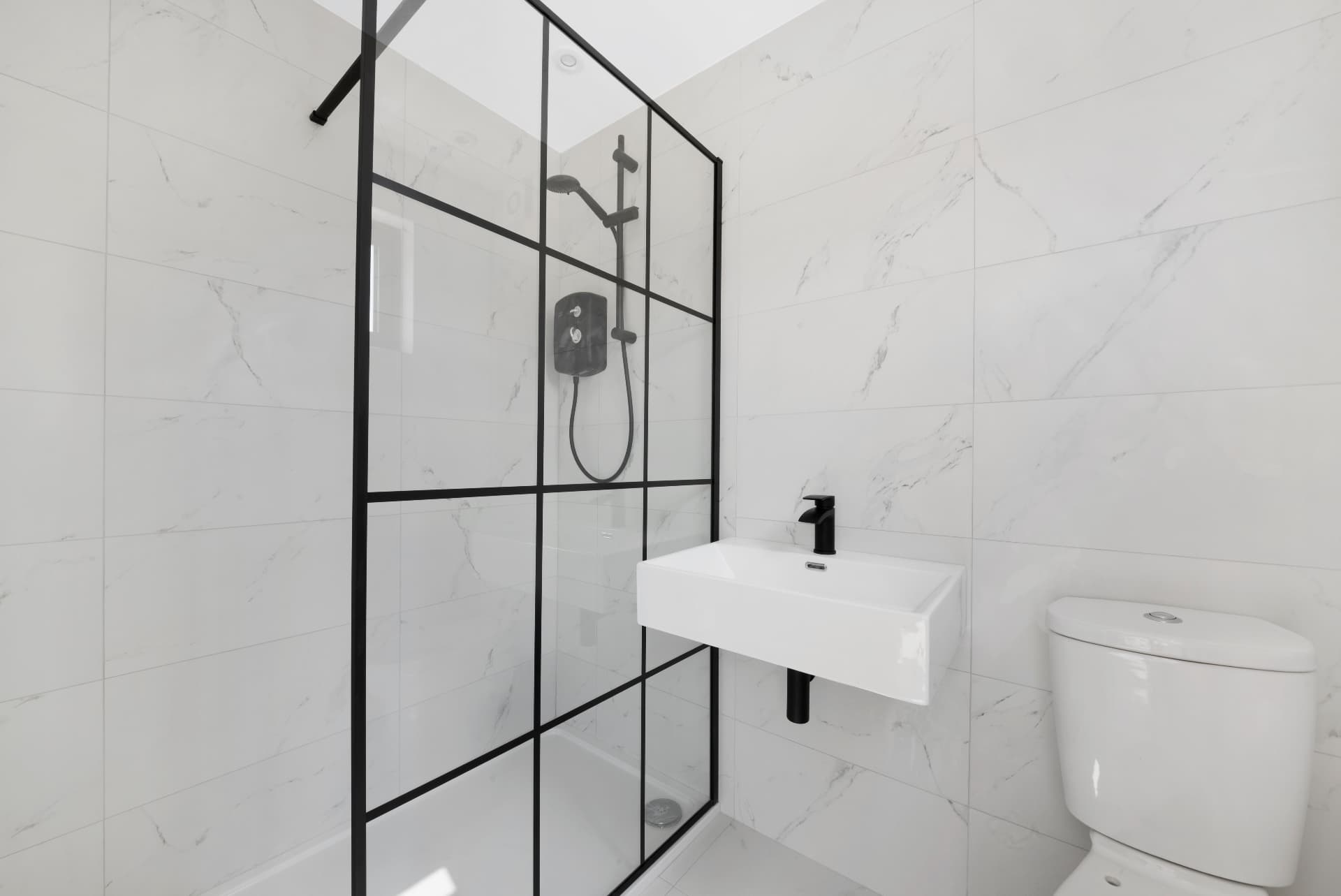 Tiled shower room with walk-in shower, basin and WC inside a 40 ft container
