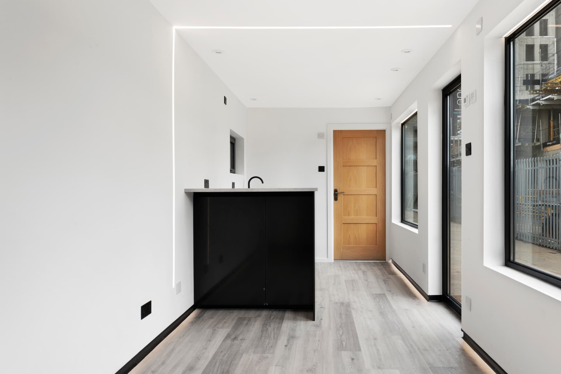 Kitchen island and oak internal door in a 40 ft container conversion with LED lighting
